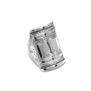 May include: A silver ring with an intricate geometric design. The ring is wide and has a curved shape.