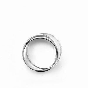 May include: A silver ring made of three interlocking bands.