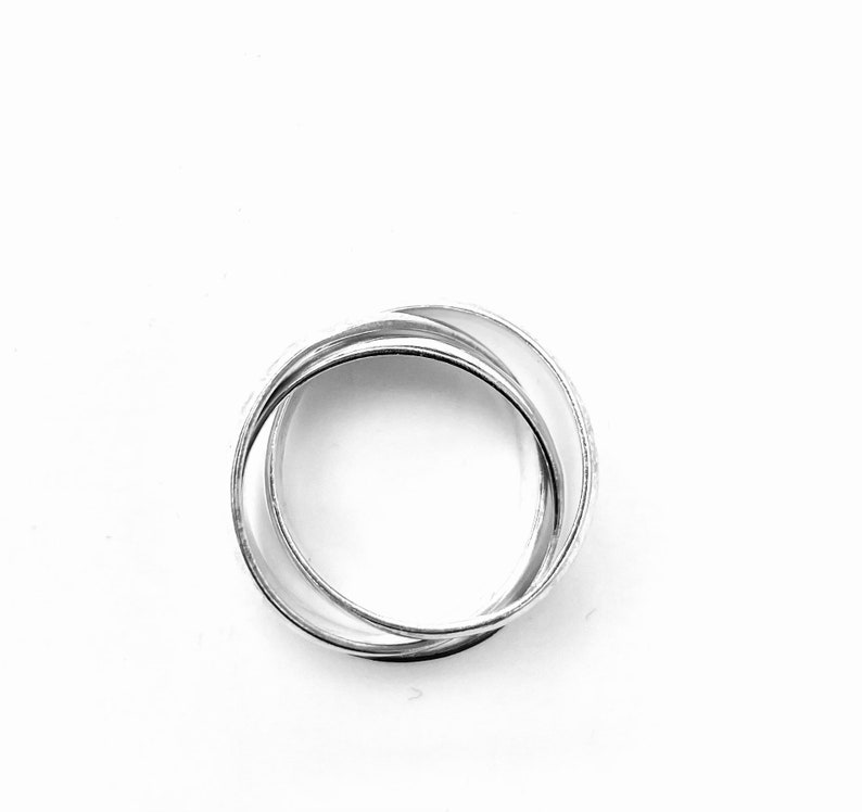 May include: A silver ring made of three interlocking bands.
