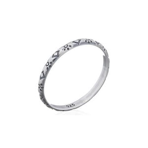 Puede incluir: Un anillo de plata con un patrón geométrico alrededor de la banda. El anillo está marcado con "925" en el interior.