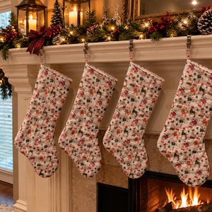 May include: Four quilted Christmas stockings hanging in a row, each featuring a repeating pattern of small illustrated dogs, green pine trees, and red gift boxes on a white background, suspended from silver metal hooks on a white fireplace mantel.