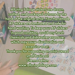 May include: A sheet of stickers featuring various designs, including a snowman, a cat, and a fish. The stickers are drawn, crafted, and packaged at home by the original artist. The text on the sheet reads: "Alluring Foliage stickers are drawn, crafted, and packaged at home by the hand of the original artist. Your handmade AF stickers are laminated and safe for hand washing. To keep your AF stickers in good condition, avoid any harsh chemicals and dishwasher exposure, which may cause discoloration and excessive wear. Thank you for supporting an artist owned small business! Glenna Belton www.alluringfoliage.com"