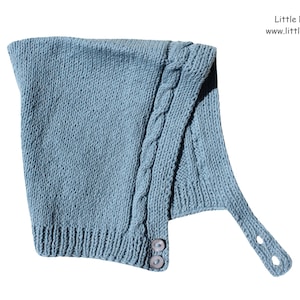 May include: A light blue knitted baby hat with a cable knit design and a strap with two buttons. The hat is made by Little Natural Knits.