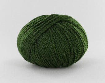 May include: A round ball of dark forest green yarn. The yarn features a multi-ply twisted construction with a visible fiber texture throughout the spherical shape. The deep green color is consistent across the entire surface of the yarn ball.