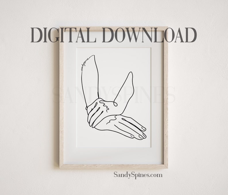May include: A black and white line drawing of two hands intertwined, with the word "goodness" written on the arm. The artwork is framed in a light wood frame.