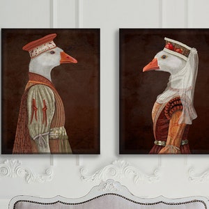May include: Two framed illustrations of geese dressed in medieval clothing. The goose on the left is wearing a red hat and a brown and red robe. The goose on the right is wearing a white hat and a red and gold robe.