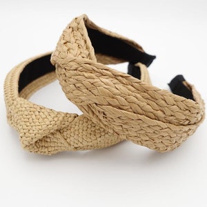 K&ouml;nnte beinhalten: Zwei gekn&uuml;pfte Strohh&auml;reifen mit einem schwarzen Gummiband. Die Haarreifen sind aus geflochtenem Stroh und haben eine nat&uuml;rliche beige Farbe.