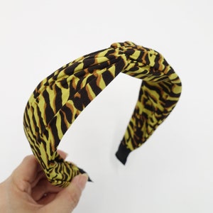 May include: A yellow and brown zebra print knotted headband.