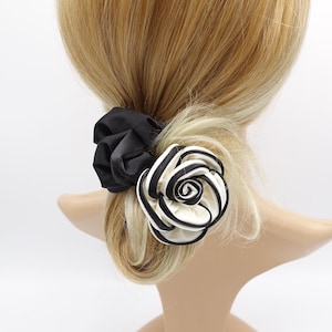 May include: Black and white striped fabric rose hair clip with a black scrunchie.