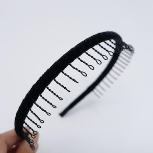 Puede incluir: Diadema de terciopelo negro con una fila de dientes de metal en la parte superior. Los dientes están diseñados para sujetar el cabello en su lugar.
