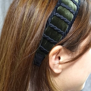May include: A black and green velvet headband with a braided design.