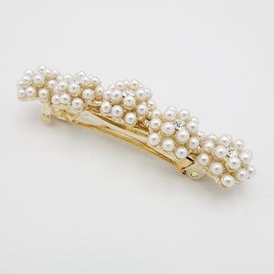 May include: Gold hair clip with three pearl flower embellishments. The clip is curved and has a gold metal base.