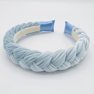 May include: A light blue velvet headband with a braided design. The headband is made of soft, comfortable material and is perfect for adding a touch of elegance to any outfit.