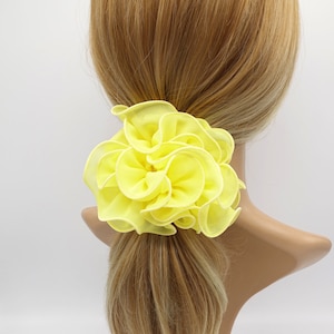 Peut inclure: Un chouchou pour cheveux en forme de fleur jaune vif.