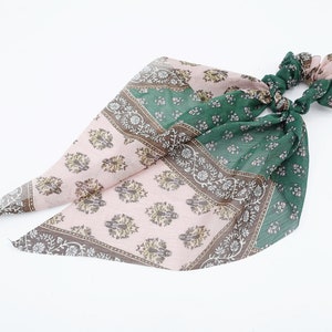 May include: A green and pink patterned hair scrunchie with a knotted bow.