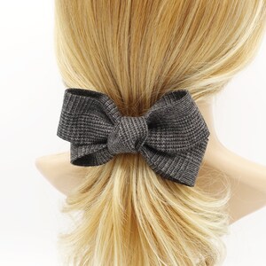 May include: A grey textured bow hair clip. The bow is tied in a large, loose knot.