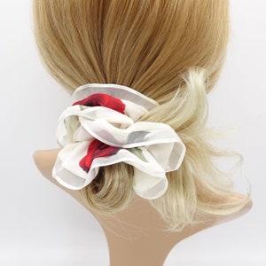 May include: White chiffon hair scrunchie with a red rose print.