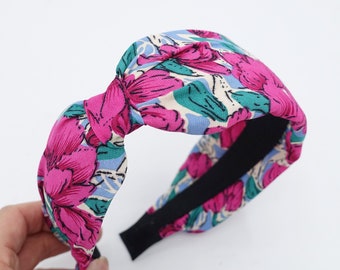 May include: A pink and blue floral patterned knotted headband with a black elastic band.