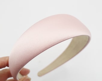 May include: A wide, pink satin headband with a padded, curved design.