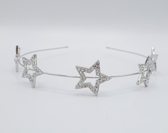 Puede incluir: Diadema plateada con cuatro adornos en forma de estrella, cada uno con brillantes transparentes.