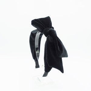 Puede incluir: Una diadema de terciopelo negro con un gran lazo. La diadema está hecha de un material suave y elástico y es perfecta para añadir un toque de elegancia a cualquier atuendo.