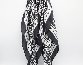May include: Black and white paisley patterned bandana with stars, tied with a black scrunchie.