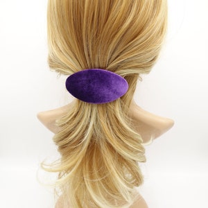 May include: A purple velvet oval hair clip for holding a ponytail or bun.
