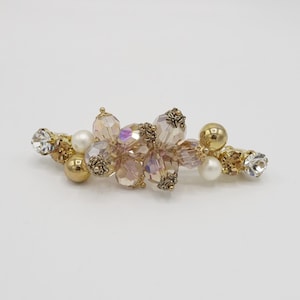 May include: A gold and iridescent hair clip with a cluster of pink and clear glass beads, gold accents, and white pearls.