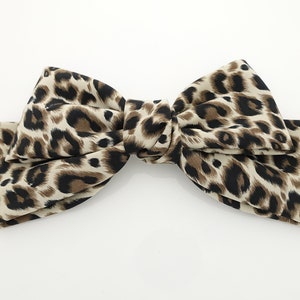 May include: A large brown and black leopard print bow hair clip.