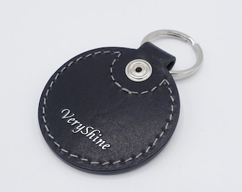 May include: A black leather keychain with a silver ring and the text "VeryShine" embossed on the front.