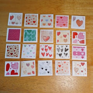 May include: A collection of twenty square cards arranged in a grid, each featuring a unique heart-themed pattern. The designs include various colors such as red, pink, black, and blue, with motifs like solid hearts, outlined hearts, and polka dots.