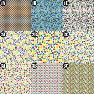 Op de afbeelding: Negen verschillende stoffenpatronen met verschillende symbolen voor autismebewustzijn, waaronder puzzelstukjes, handafdrukken en oneindigheidssymbolen. De patronen zijn in tinten blauw, geel, groen en rood op een witte achtergrond.
