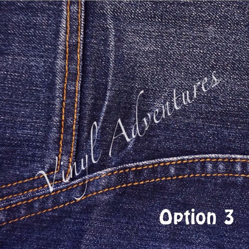 K&ouml;nnte beinhalten: Nahaufnahme von blauem Jeansstoff mit zwei Reihen orangefarbener N&auml;hte. Der Text "Vinyl Adventures" ist in Kursivschrift &uuml;ber den Stoff geschrieben. Der Text "Option 3" ist in Wei&szlig; unter den N&auml;hten geschrieben.