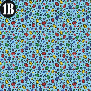 Autism Cheetah print with puzzle pieces and cheetah spots in red, green, yellow and blue with light blue background.