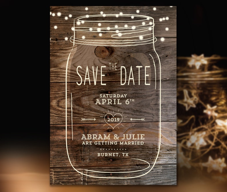 May include: Rustic wood background with a white outline of a mason jar with string lights. The text "THE SAVE DATE" is written in white with the date "SATURDAY APRIL 6TH 2019" and the names "ABRAM & JULIE ARE GETTING MARRIED BURNET, TX".