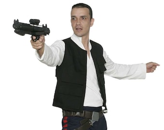 May include: A person dressed as Han Solo from Star Wars. They are wearing a black vest, white shirt, blue trousers, and brown boots. They are holding a blaster pistol in their right hand.