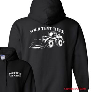 May include: Black hooded sweatshirt with a white outline of a front-end loader and the text "YOUR TEXT HERE" on the back.