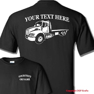 May include: Black t-shirt with a white outline of a tow truck and the text "YOUR TEXT HERE" on the back. The front of the shirt has the text "YOUR TEXT OR NAME" in white.