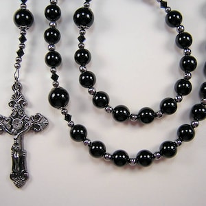 May include: Black onyx and silver rosary with a detailed silver crucifix.