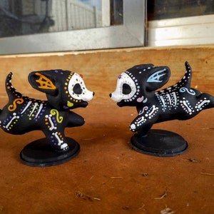 Escultura conmemorativa del Día de los Muertos con forma de cachorro de perro y calavera de azúcar, pintada a mano e impresa en 3D.