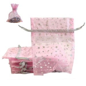 May include: A stack of pink organza gift bags with silver stars and silver ribbon ties. The bags are perfect for small gifts or favors.