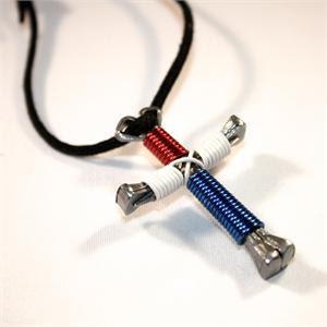 May include: A red, white, and blue wire-wrapped horseshoe nail cross pendant on a black cord.
