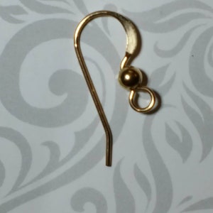 May include: Gold earring hook with a small ball at the top.