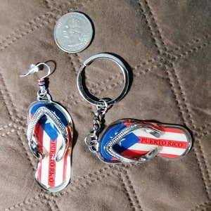May include: A pair of silver flip-flop earrings and a silver flip-flop keychain with a Puerto Rican flag design. Both items say "Puerto Rico" on them.