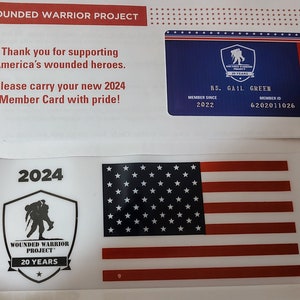 Op de afbeelding: Een witte kaart met het Wounded Warrior Project-logo en de tekst "20 Years". De kaart heeft ook een zwart-witte Amerikaanse vlag.
