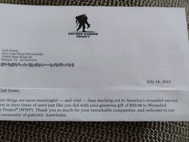 Puede incluir: Un sobre blanco con un logotipo negro de Wounded Warrior Project y un texto que dice "Gail Green, pocas cosas son m&aacute;s significativas - y vitales - que tender la mano a los militares estadounidenses heridos en sus momentos de necesidad, como lo hiciste con tu generosa donaci&oacute;n de $ 50.00 al Wounded Warrior Project&reg; (WWP). Muchas gracias por tu notable compasi&oacute;n, y bienvenido a nuestra comunidad de estadounidenses patri&oacute;ticos."
