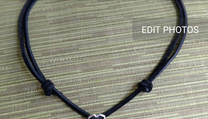 May include: A black leather cord necklace with a silver heart charm.