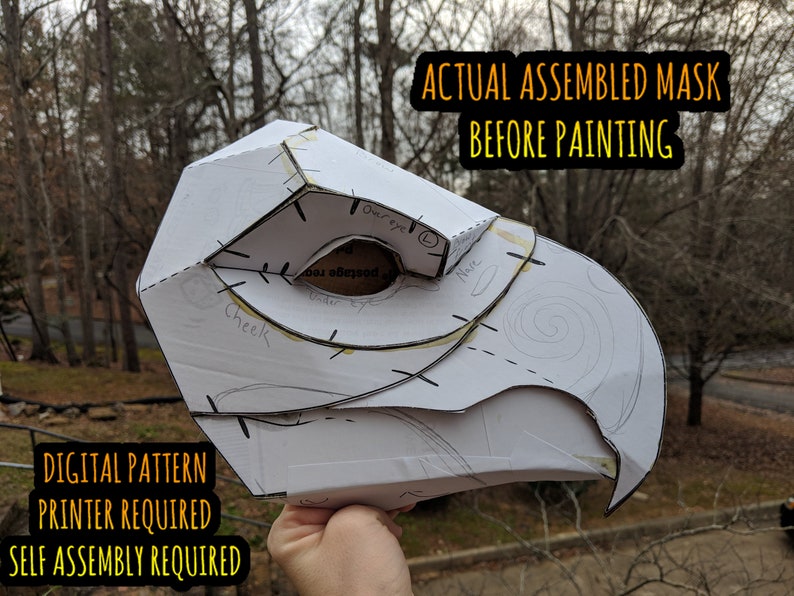 May include: A white paper mask assembled and ready for painting. The mask is shaped like a bird's head with a beak and an eye hole. The mask is labeled with the words "Cheek", "Toureye", and "Nave". The text "DIGITAL PATTERN PRINTER REQUIRED SELF ASSEMBLY REQUIRED" is visible at the bottom of the image. The text "ACTUAL ASSEMBLED MASK BEFORE PAINTING" is visible at the top of the image.