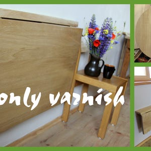 K&ouml;nnte beinhalten: Ein heller Holz-Klapptisch an der Wand mit schlichtem Design. Der Tisch ist an der Wand montiert und l&auml;sst sich platzsparend einklappen. Der Tisch ist in zwei verschiedenen R&auml;umen zu sehen, einer mit einer Blumenvase und einem Stuhl, der andere mit einem Buch und einer Tasse.