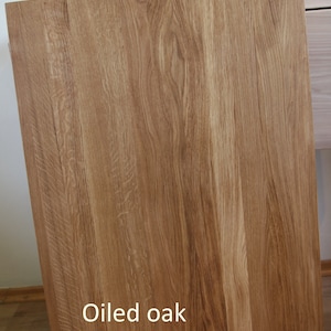 May include: Close-up of a wood surface with a natural grain pattern. The wood has been oiled and has a warm, honey-like color. The text "Oiled oak" is printed on the surface.